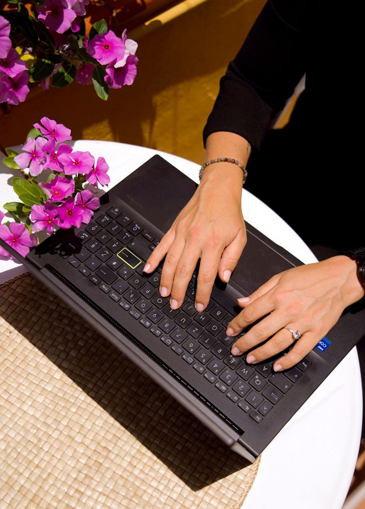 Virtuelle Assistentin werden - Bild mit Laptop auf dem Hände Tippen bei strahlendem Sonnenschein
